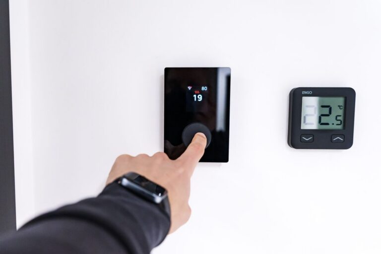 Hand die een slimme thermostaat instelt